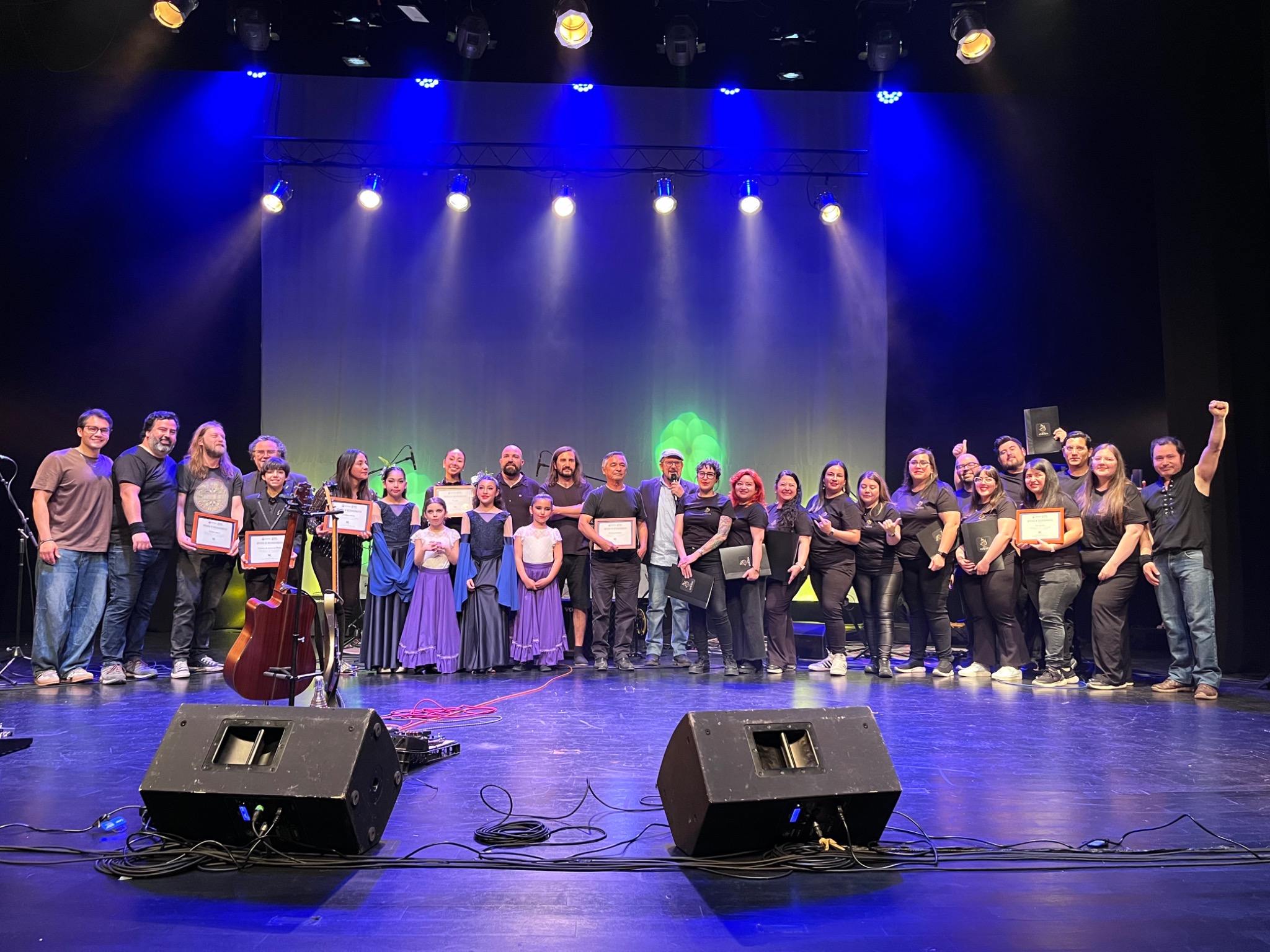 Participantes de una jornada artística reunidos sobre un escenario